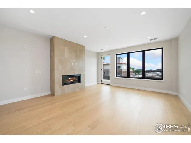 a view of an empty room with a window and fireplace