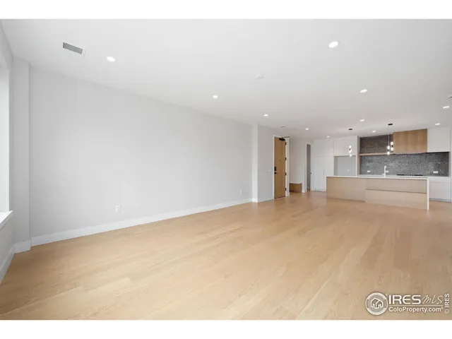a view of an empty room with a kitchen