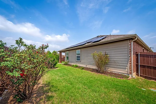 a view of a garden with house in the background