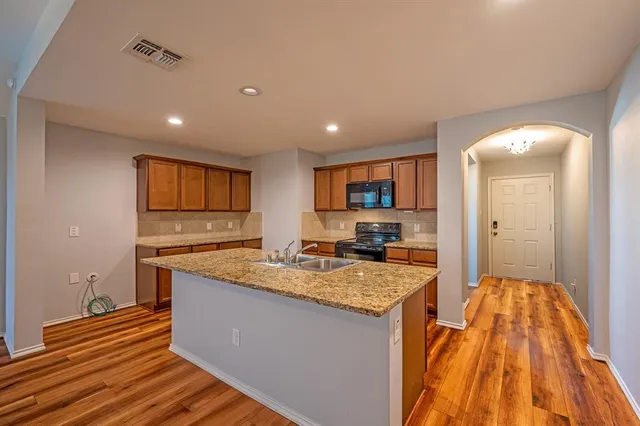 a kitchen with sink and view of living room