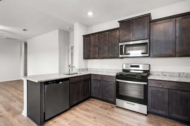 a kitchen with stainless steel appliances granite countertop a sink and stove top oven