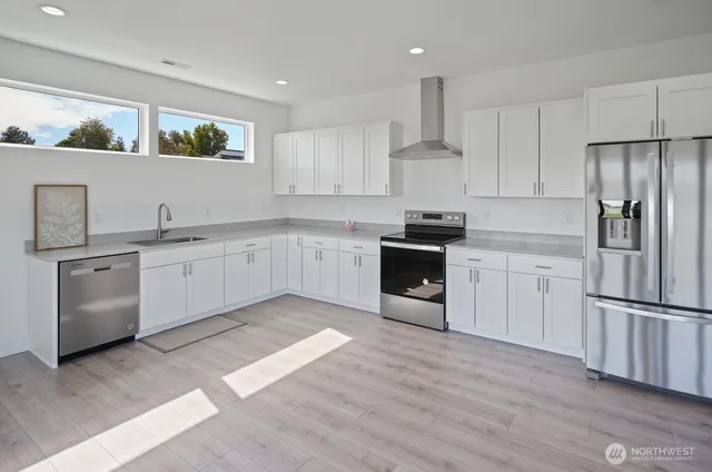 a kitchen with stainless steel appliances kitchen island granite countertop a stove and a sink