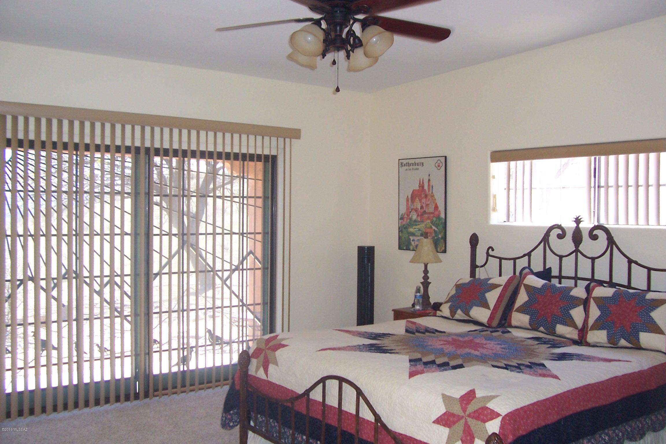 1256 Avenida Gloriosa Rio Rico, AZ 85648 - Photo 18 of 25 a bedroom with a bed and a chandelier