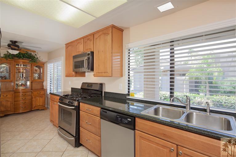 72384 Ridgecrest Lane Palm Desert, CA 92260 - Photo 9 of 23 a kitchen with granite countertop a sink and a stove top oven