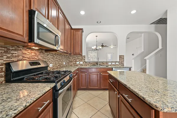 a kitchen with stainless steel appliances granite countertop a sink stove and cabinets