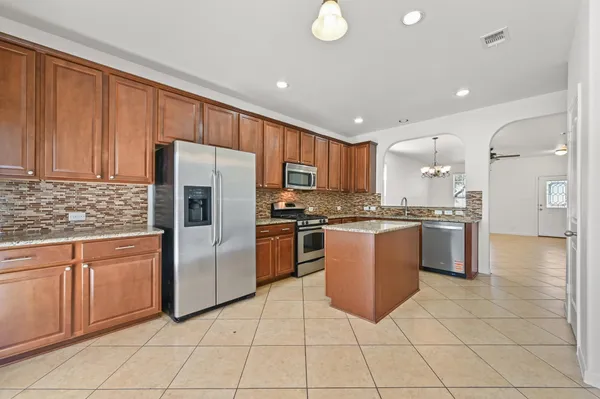 a kitchen with granite countertop a refrigerator and cabinets