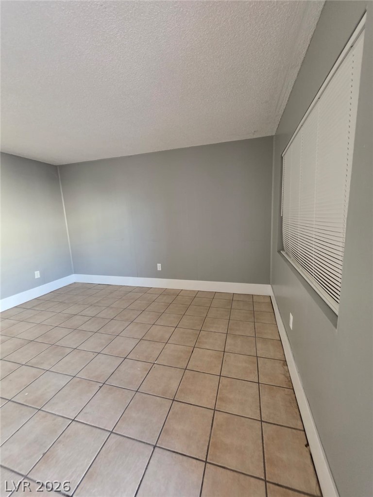 1075 East Desert Inn Road, Unit 2 Las Vegas, NV 89109 - Photo 12 of 13 Tiled flooring and neutral walls define this versatile interior space.