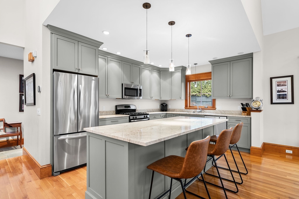 32 Standish Circle Wellesley, MA 02481 - Photo 7 of 29 a kitchen with stainless steel appliances a refrigerator a sink a stove a dining table and chairs
