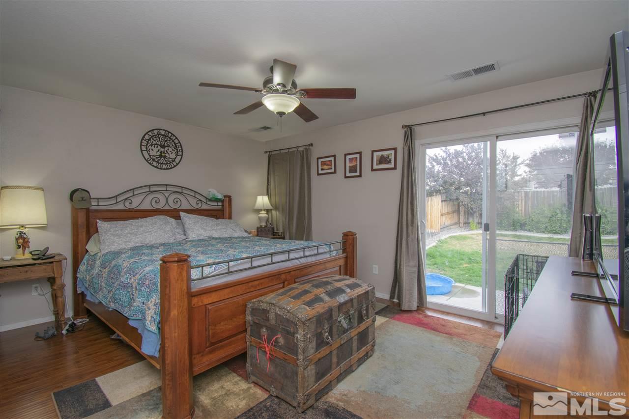 7749 Welsh Drive Reno, NV 89506 - Photo 12 of 25 a bedroom with a bed and a large window with balcony view