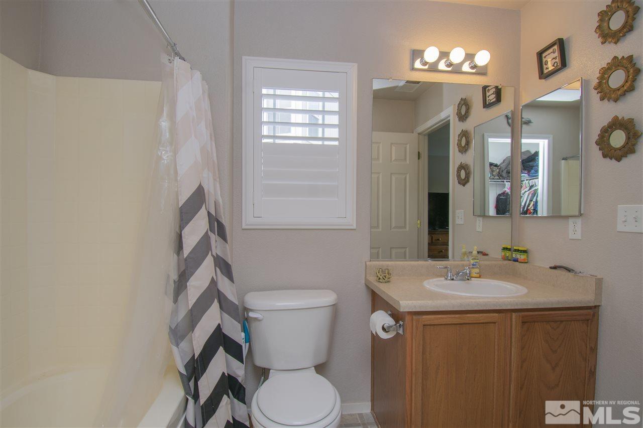 7749 Welsh Drive Reno, NV 89506 - Photo 16 of 25 a bathroom with a sink vanity mirror and toilet