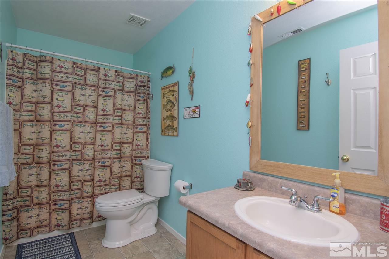 7749 Welsh Drive Reno, NV 89506 - Photo 17 of 25 a bathroom with a sink a toilet and shower curtain