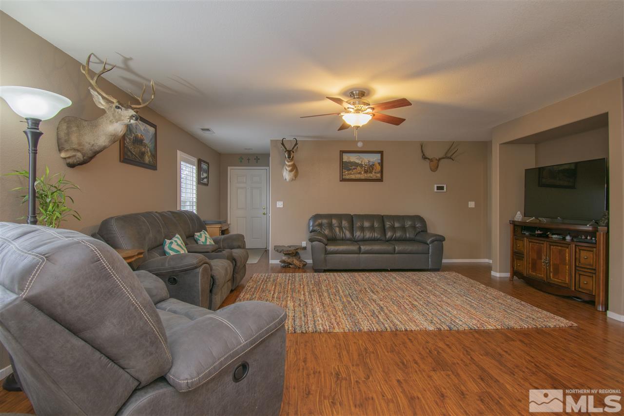 7749 Welsh Drive Reno, NV 89506 - Photo 5 of 25 a living room with furniture a flat screen tv and kitchen view
