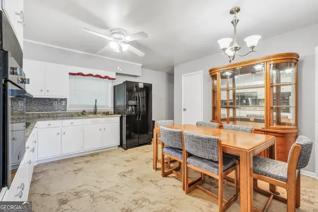 a very nice looking dining room with a large window and chandelier