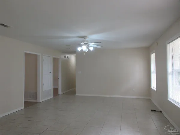 an empty room with a window and a fan