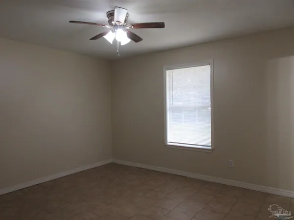 an empty room with closet and a ceiling fan