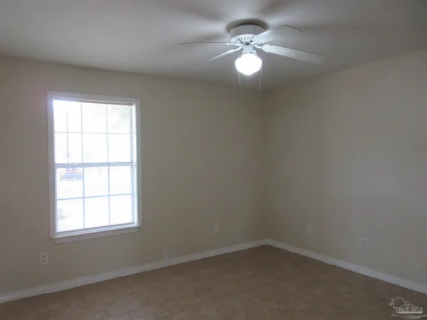 a view of an empty room and chandelier fan