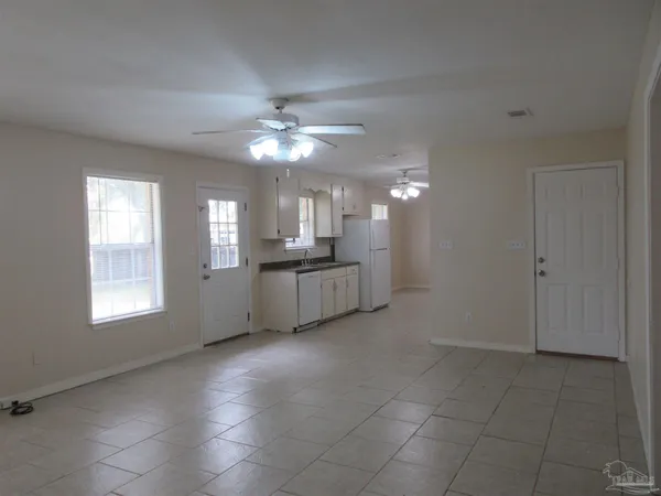 a view of an empty room with a kitchen
