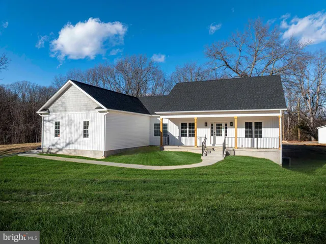a front view of a house with a yard and trees