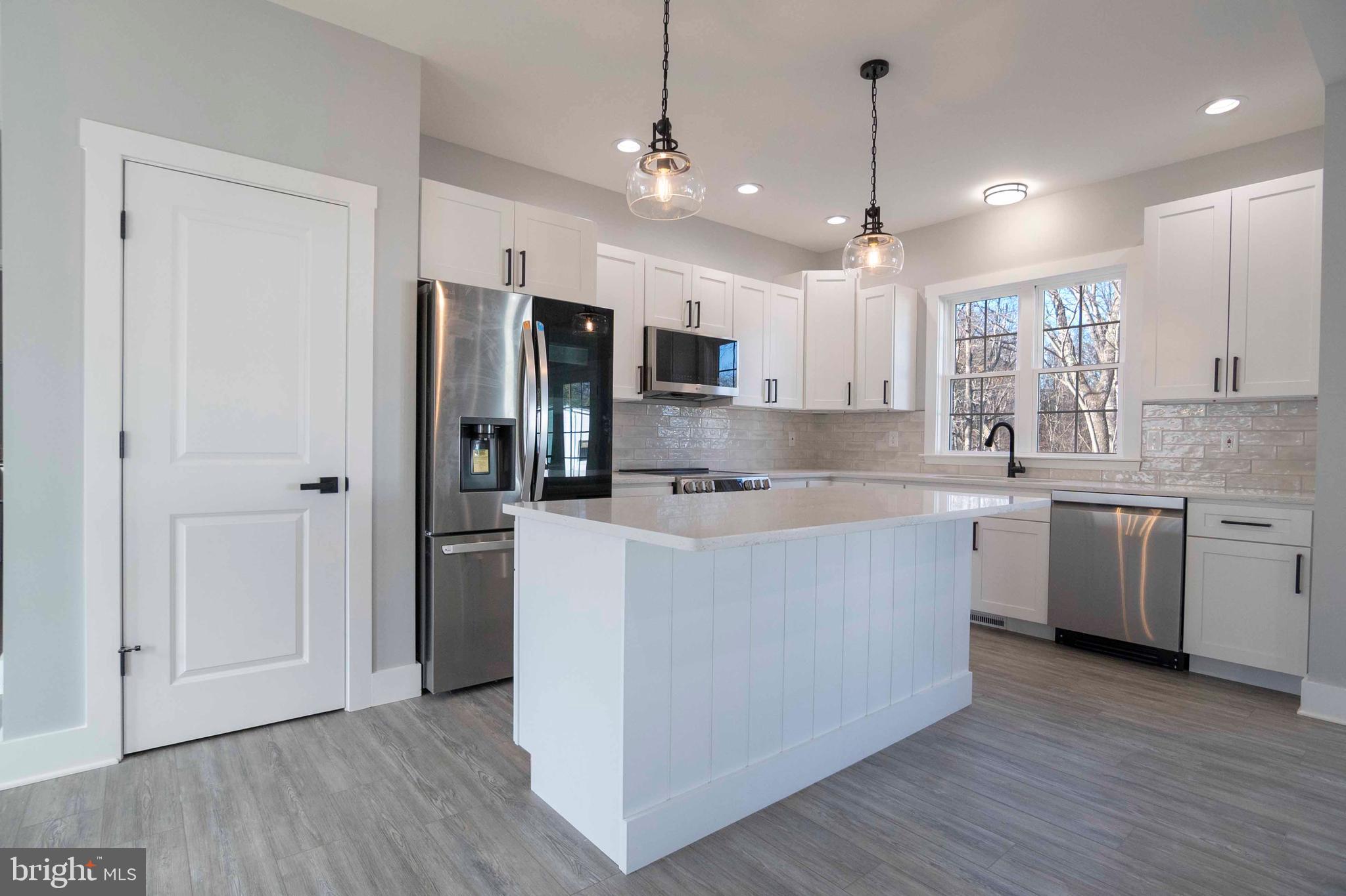 1633 Catlett Mountain Road Front Royal, VA 22630 - Photo 22 of 69 a large kitchen with stainless steel appliances kitchen island a large counter top a sink a refrigerator and a window