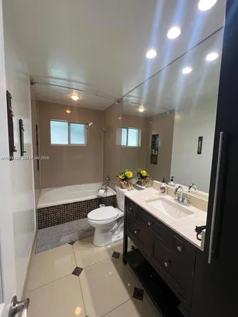 a spacious bathroom with a double vanity sink toilet and a mirror