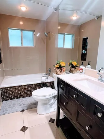 a bathroom with a sink a toilet a mirror and shower