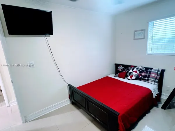 a bed sitting in a bedroom next to a window with pc on the wall