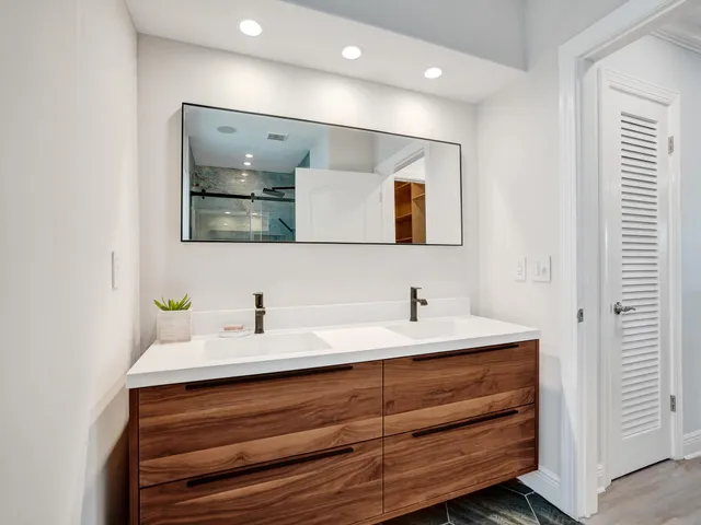 a large kitchen with stainless steel appliances kitchen island granite countertop a refrigerator and a sink