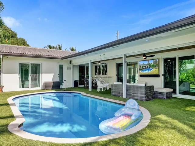 a view of a house with swimming pool and sitting area