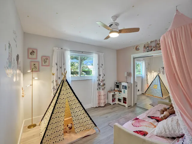 a front view of a house with a yard and potted plants