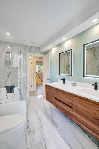 a large white kitchen with a large window and stainless steel appliances