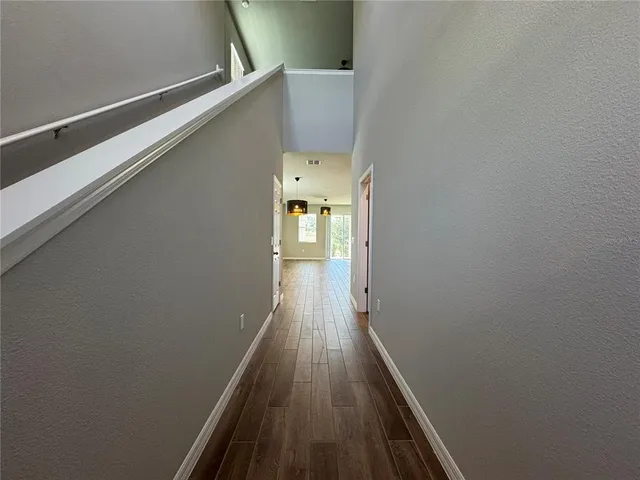 a view of a hallway with wooden floor