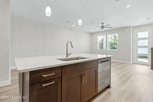 a kitchen with a sink cabinets and wooden floor