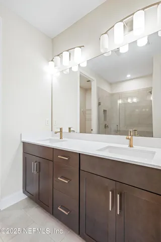 a bathroom with a double vanity sink and a mirror