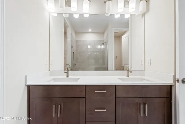 a bathroom with a double vanity sink and a mirror