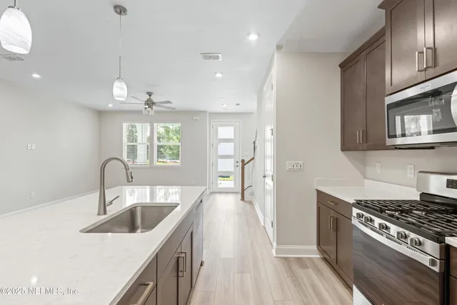 a kitchen with granite countertop a sink stove and cabinets