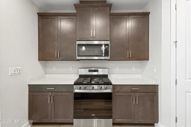 a kitchen with granite countertop a stove and a microwave