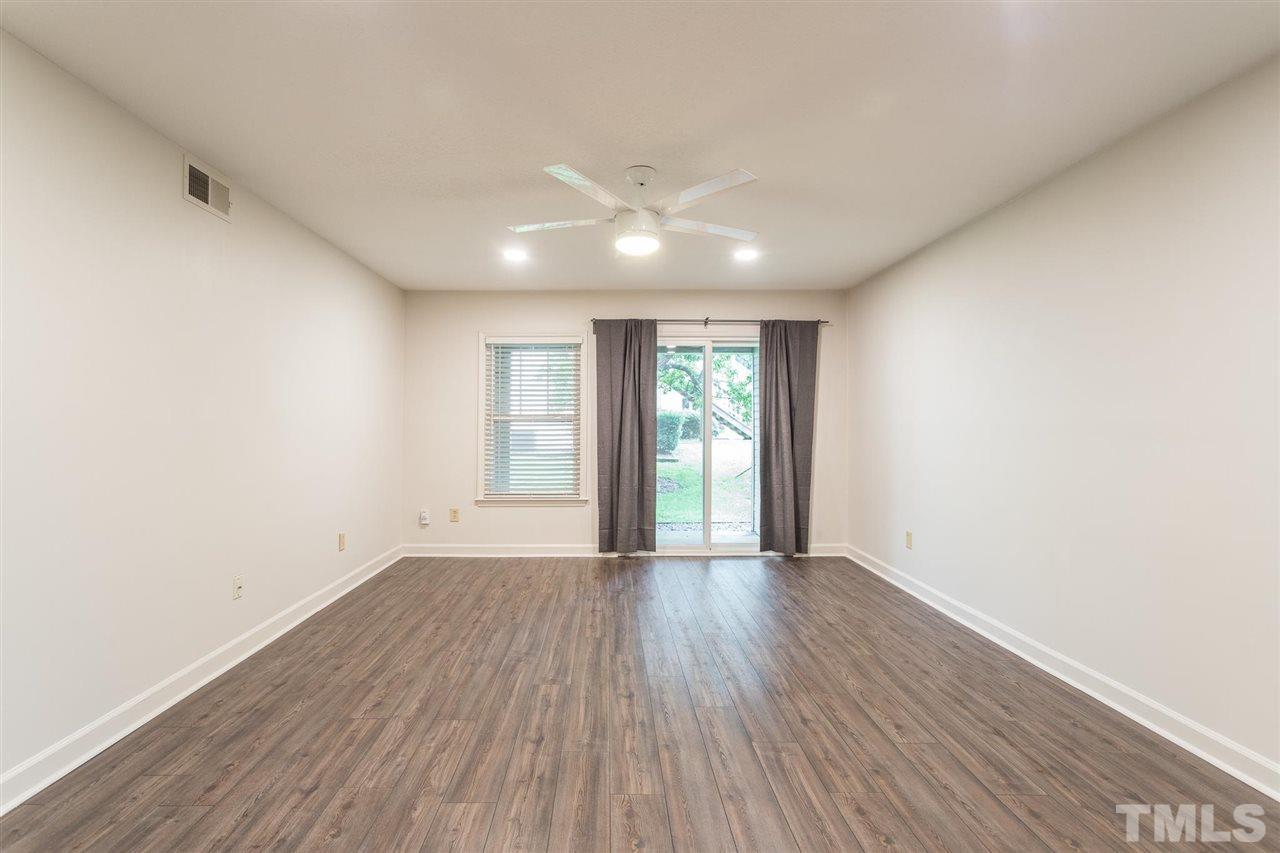 2516 Avent Ferry Road, Unit 101 Raleigh, NC 27606 - Photo 13 of 27 an empty room with wooden floor and windows