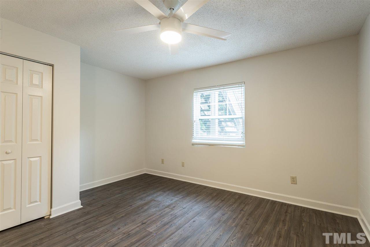 2516 Avent Ferry Road, Unit 101 Raleigh, NC 27606 - Photo 15 of 27 an empty room with wooden floor fan and windows