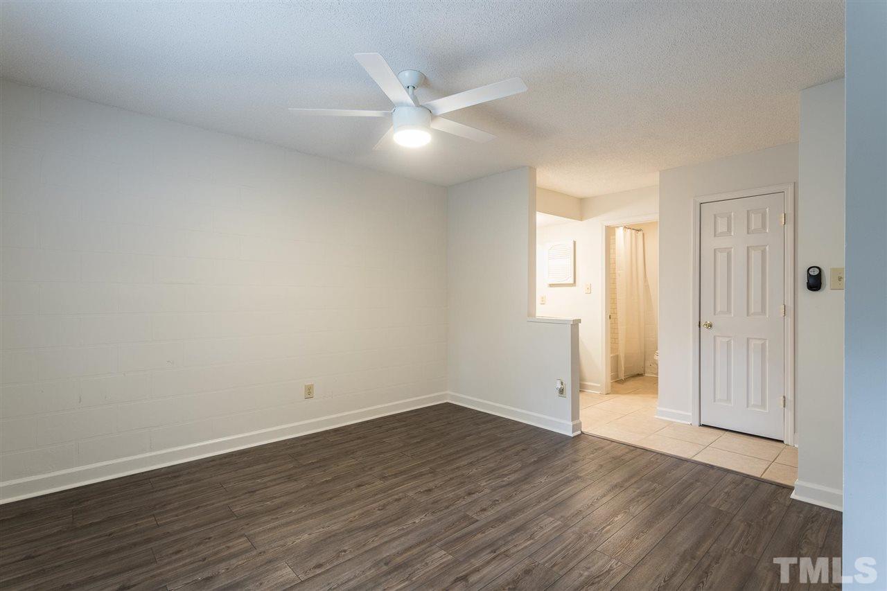 2516 Avent Ferry Road, Unit 101 Raleigh, NC 27606 - Photo 17 of 27 an empty room with wooden floor and windows
