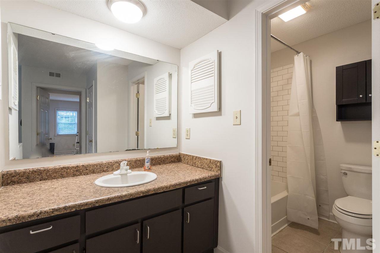 2516 Avent Ferry Road, Unit 101 Raleigh, NC 27606 - Photo 18 of 27 a bathroom with a granite countertop sink toilet and shower