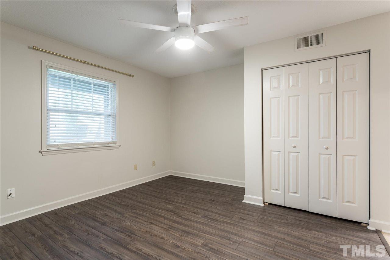 2516 Avent Ferry Road, Unit 101 Raleigh, NC 27606 - Photo 20 of 27 an empty room with wooden floor cabinet and windows