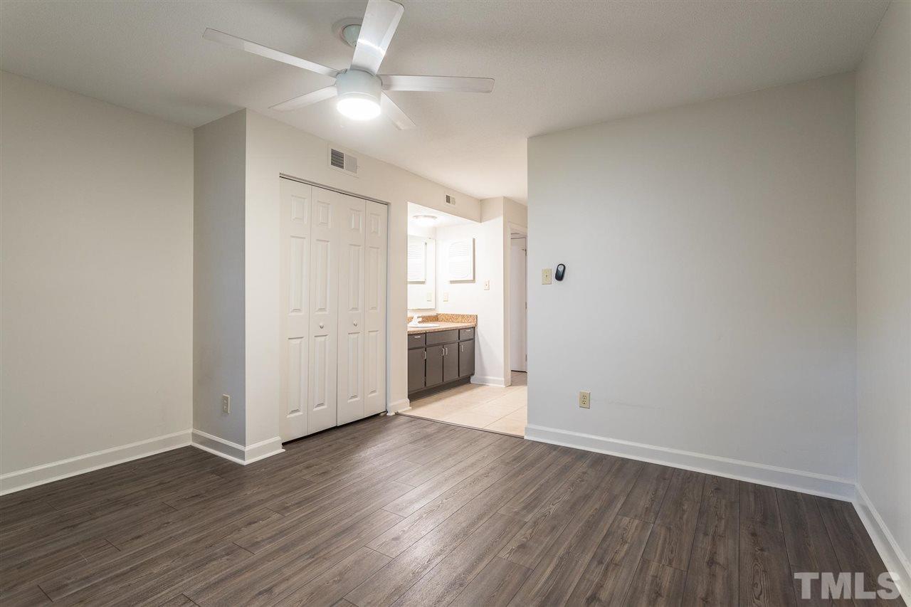 2516 Avent Ferry Road, Unit 101 Raleigh, NC 27606 - Photo 21 of 27 an empty room with wooden floor and a ceiling fan