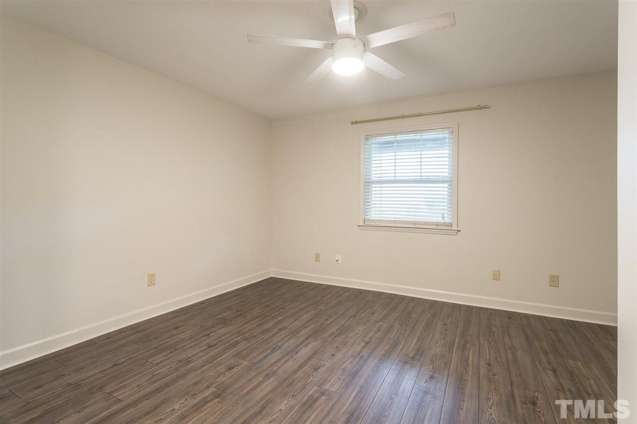 2516 Avent Ferry Road, Unit 101 Raleigh, NC 27606 - Photo 22 of 27 an empty room with wooden floor and windows