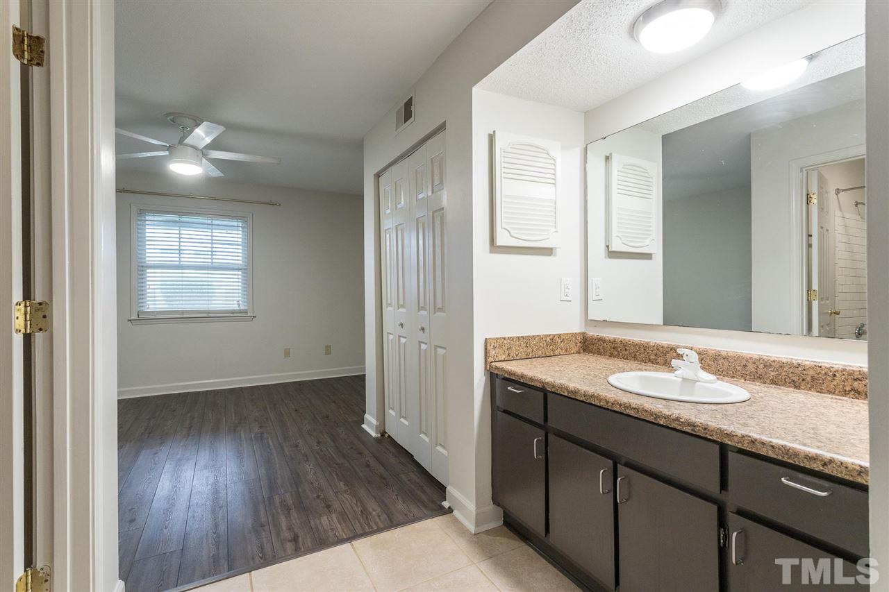 2516 Avent Ferry Road, Unit 101 Raleigh, NC 27606 - Photo 23 of 27 a bathroom with a granite countertop sink and a mirror