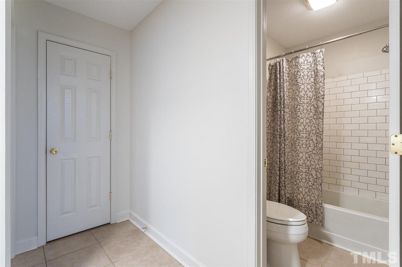 2516 Avent Ferry Road, Unit 101 Raleigh, NC 27606 - Photo 24 of 27 a bathroom with a shower curtain and a toilet