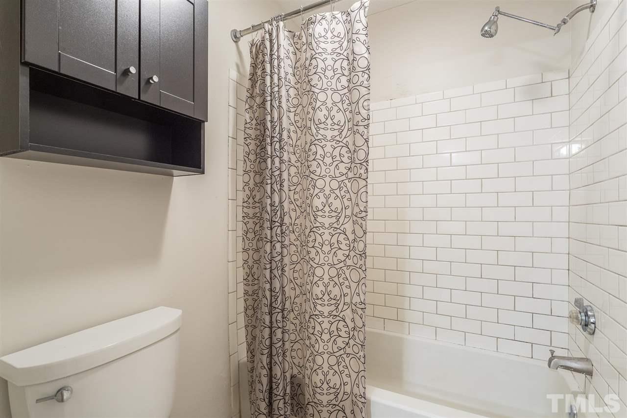 2516 Avent Ferry Road, Unit 101 Raleigh, NC 27606 - Photo 25 of 27 a bathroom with a shower curtain and a toilet