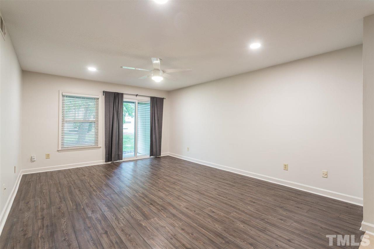 2516 Avent Ferry Road, Unit 101 Raleigh, NC 27606 - Photo 10 of 27 a view of an empty room with wooden floor and a window