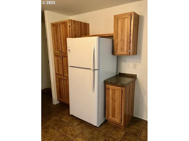 a white refrigerator freezer and a stove sitting inside of a kitchen