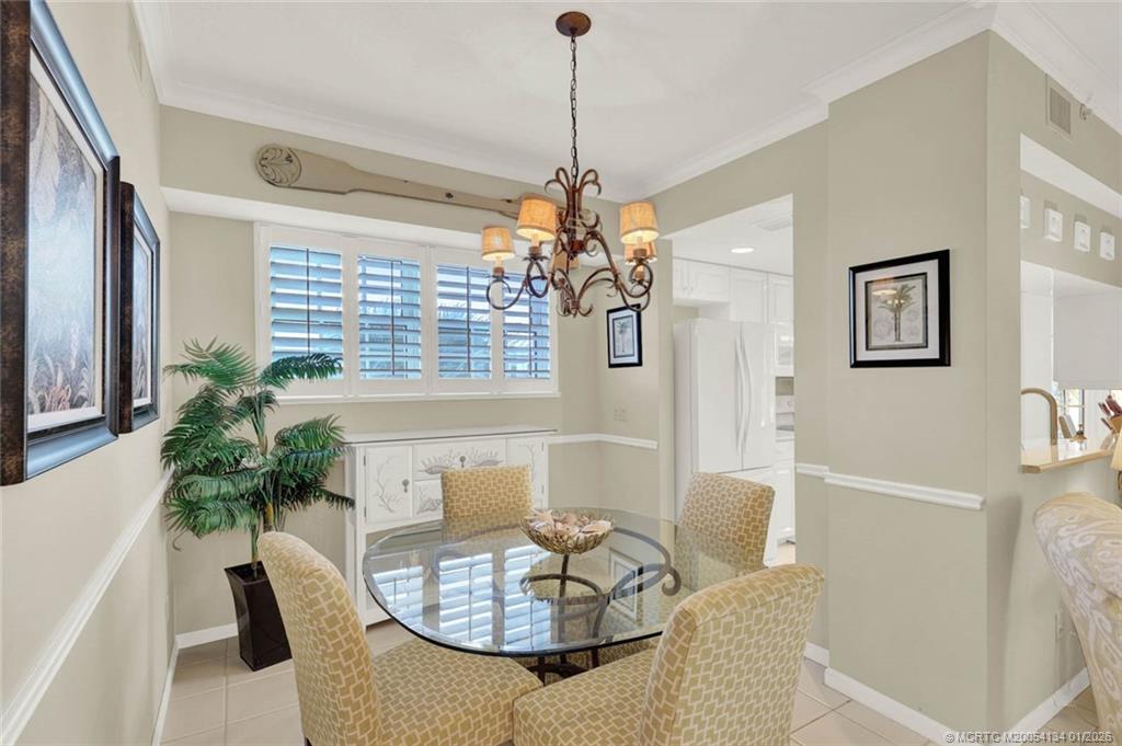 5700 Northeast Island Cove Way, Unit 4301 Stuart, FL 34996 - Photo 13 of 45 a dining room with furniture a livingroom and chandelier