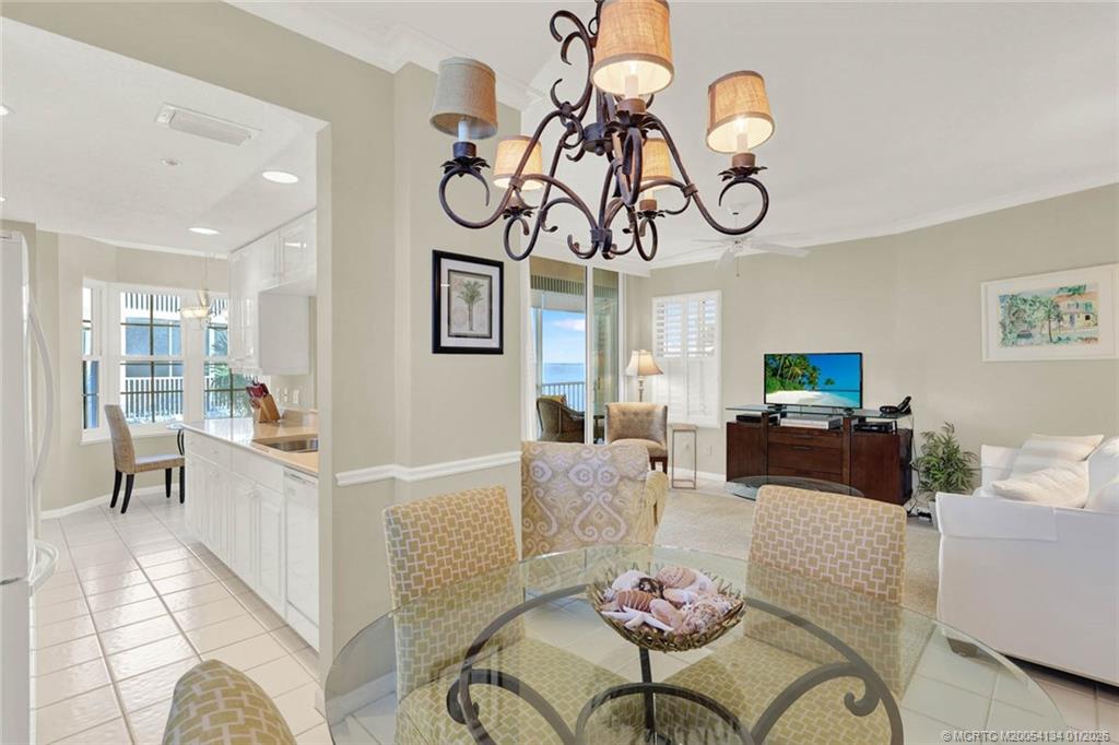 5700 Northeast Island Cove Way, Unit 4301 Stuart, FL 34996 - Photo 14 of 45 a living room with furniture a flat screen tv and a table